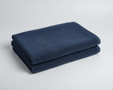 Folded navy blue towel on a wooden surface